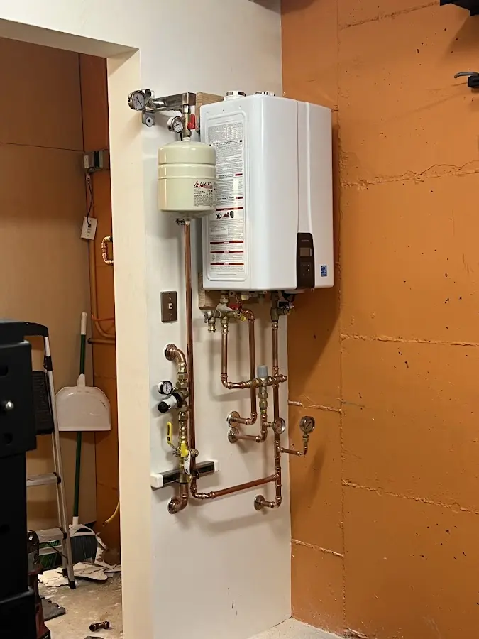 Plumbing technician inspecting water heater connections in Blackfoot